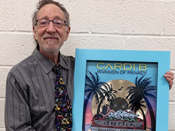 Prof. Bruce Colfin holding the Cardi B Invasion of Privacy plaque